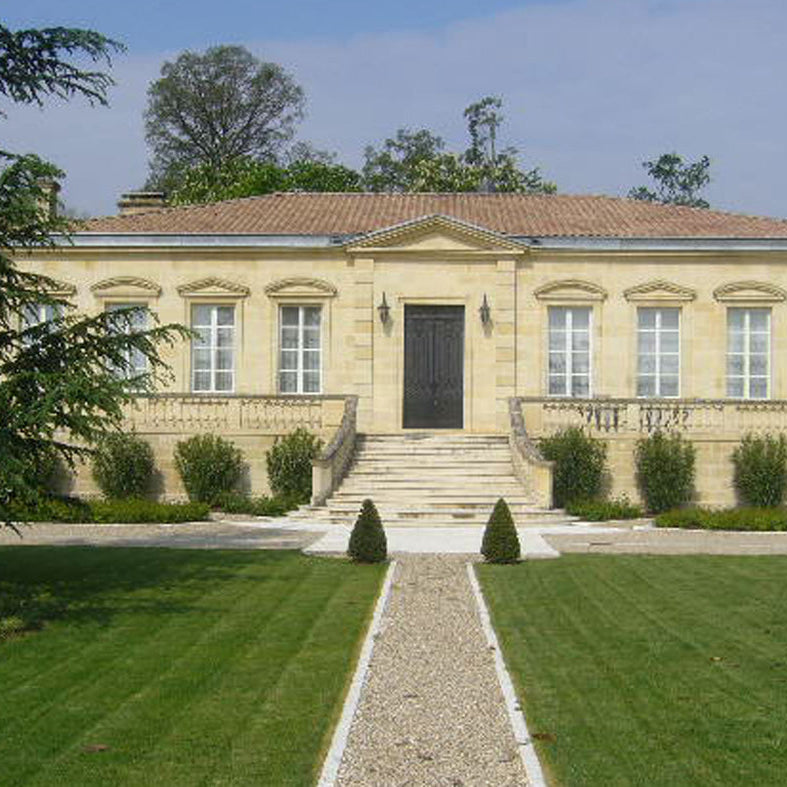 Front view of Château Figeac, a beautiful historic estate in Saint-Émilion with classical architecture, manicured lawns, and a grand staircase leading to the entrance.