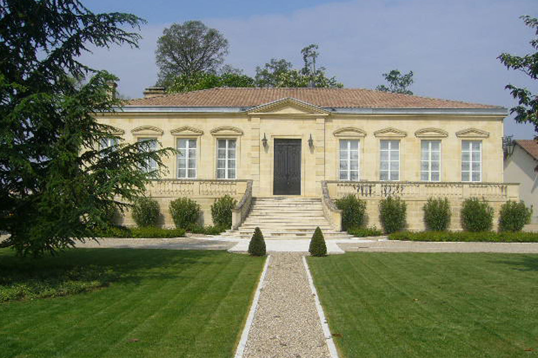 Front view of Château Figeac, a beautiful historic estate in Saint-Émilion with classical architecture, manicured lawns, and a grand staircase leading to the entrance.