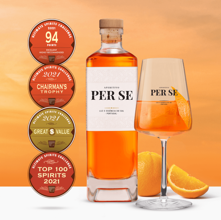 Per Se Aperitivo bottle with a branded glass, orange slice garnish, and award badges from Ultimate Spirits Challenge.