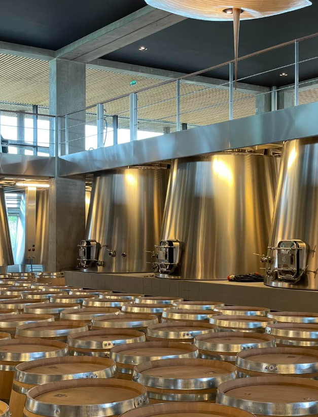 Modern stainless steel and wooden barrel room at a luxury winery.