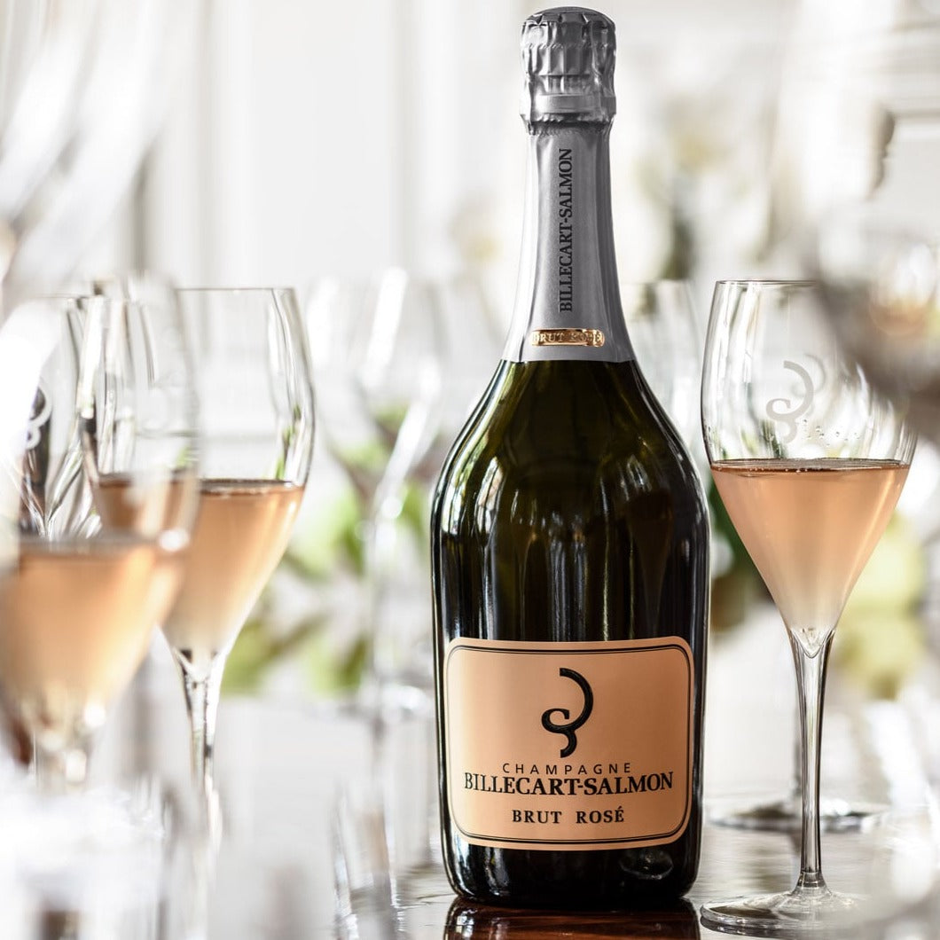 Bottle of Billecart-Salmon Brut Rosé Champagne elegantly surrounded by filled glasses.