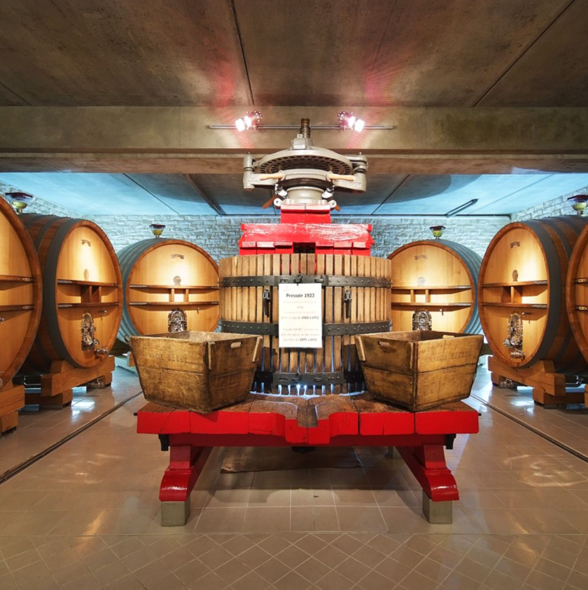 Champagne Gruet's historic press room with oak barrels and traditional equipment.