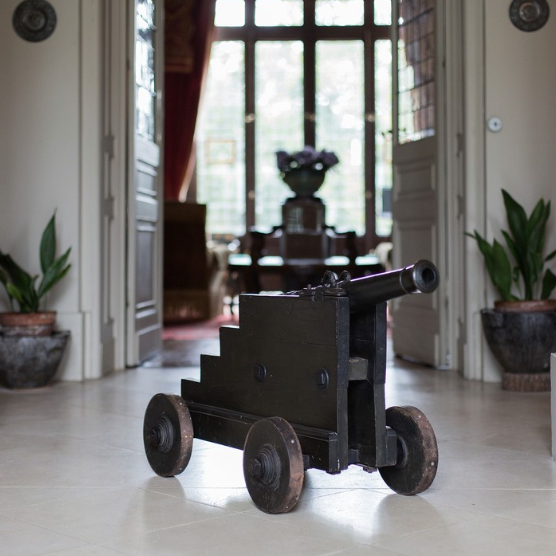 Historic cannon displayed inside the grand interior of Chateau Batailley, reflecting the winery's rich legacy and elegance.