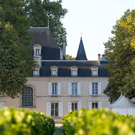 The elegant Château Cantemerle estate surrounded by greenery in the Bordeaux region.