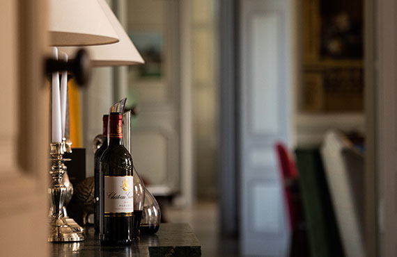 Château Giscours wine bottle elegantly displayed indoors on a polished surface, with a refined, classic décor in the background, highlighting the luxury and sophistication of the Margaux estate's renowned Bordeaux Grand Cru wines.