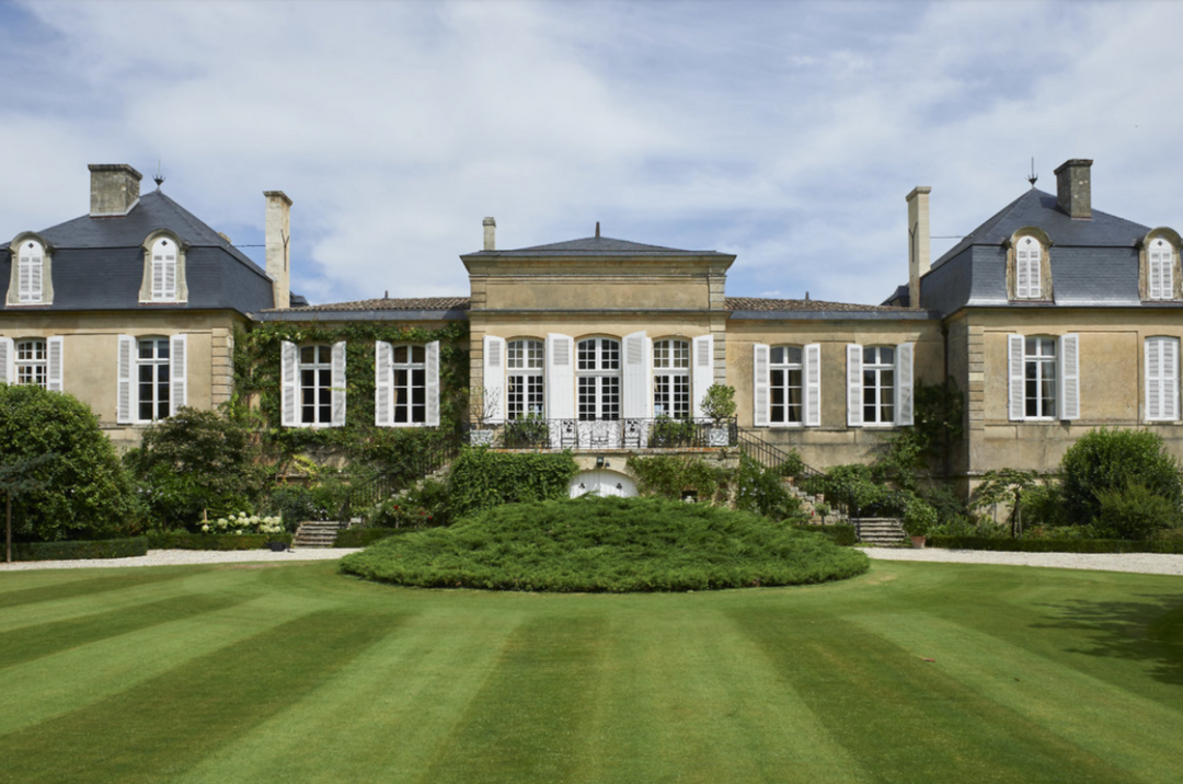 Front view of the Chateau Langoa-Barton main building surrounded by a beautifully maintained lawn.