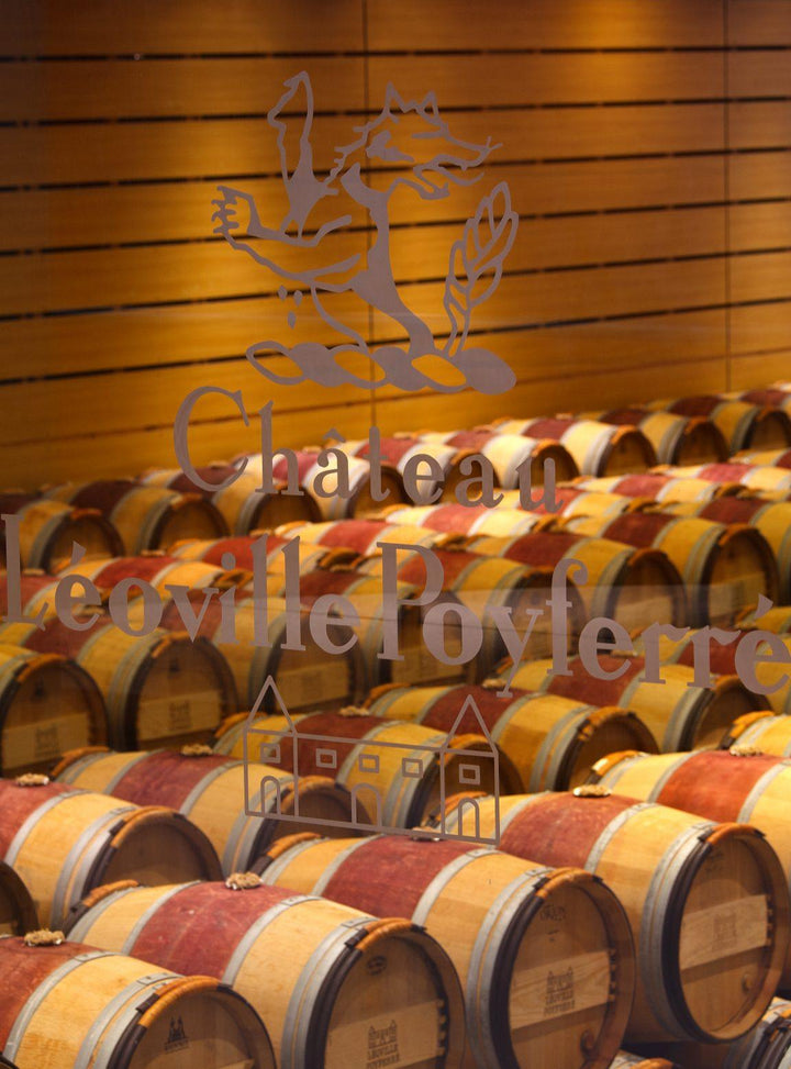 Oak barrels aging wine in the cellar of Château Léoville-Poyferré.