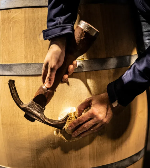 Sealing a wine barrel at Château Palmer with traditional craftsmanship.