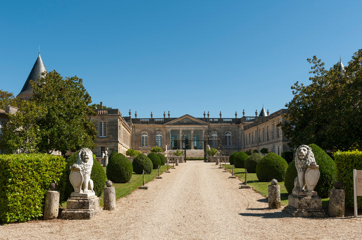 The grand entrance of Château Saint-Georges in Saint-Émilion, with its impressive architecture and beautifully landscaped gardens.