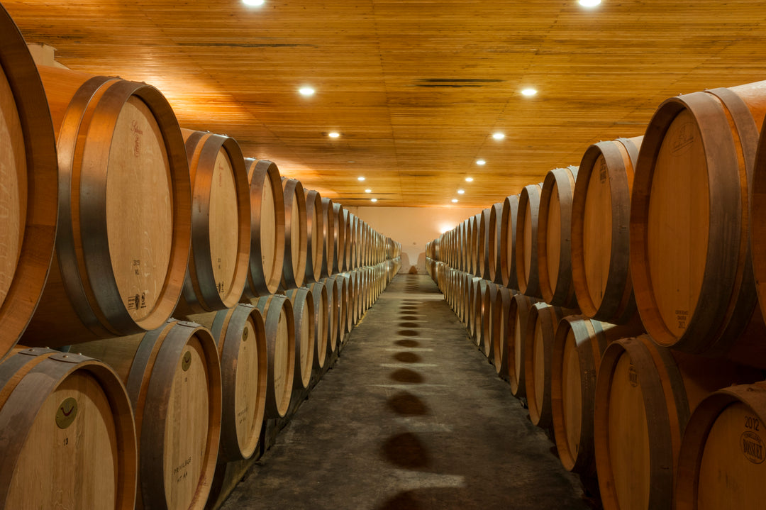 A wine cellar lined with wooden barrels at Château Saint-Georges, where fine Bordeaux wines age to perfection.