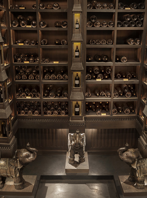 The opulent private wine cellar of Cos d'Estournel, with intricately designed shelves filled with rare wine bottles.