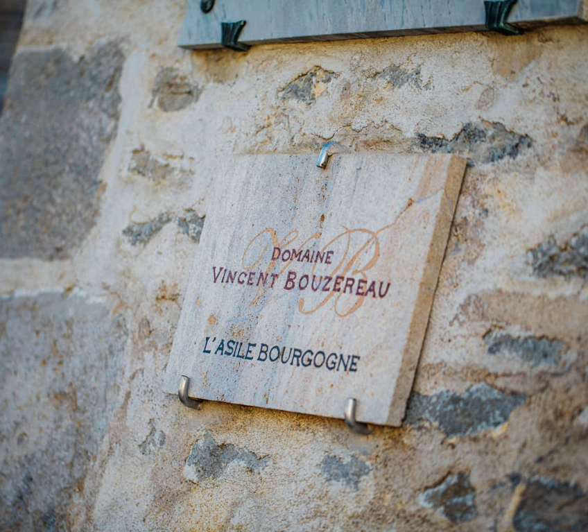 A close-up of the Domaine Vincent Bouzereau sign at the estate in Burgundy.