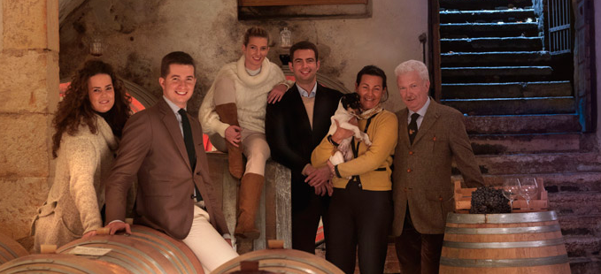 The Domenico Fraccaroli family inside their wine cellar, surrounded by barrels, celebrating their winemaking heritage.