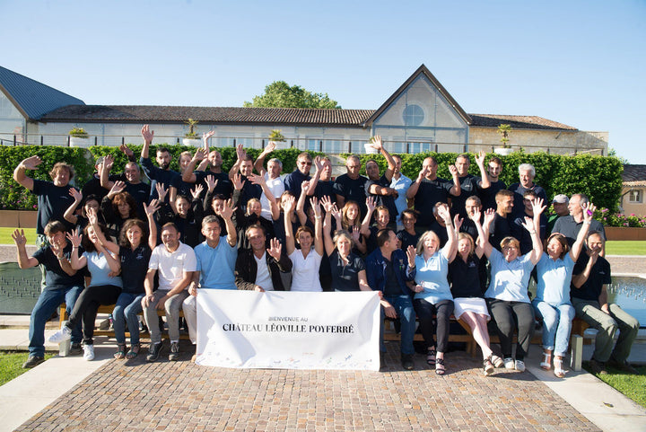 The Château Léoville-Poyferré team celebrating together in front of the estate.