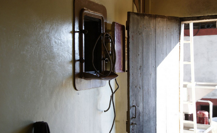 A rustic winery door with an old fermentation tank, reflecting historic winemaking charm.