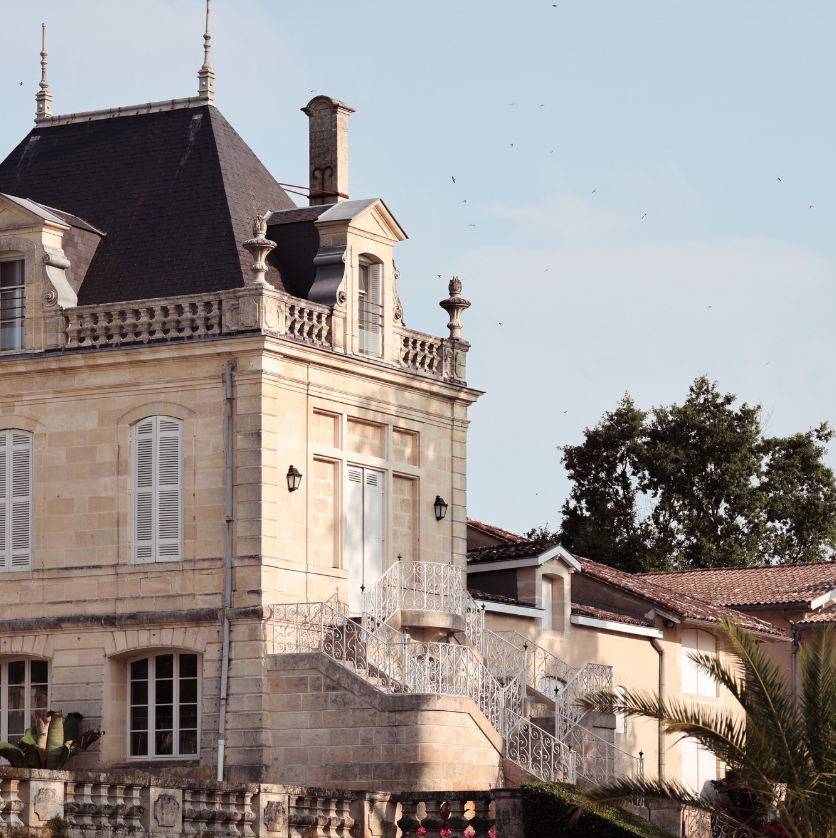 A historic chateau-style winery estate surrounded by lush gardens.