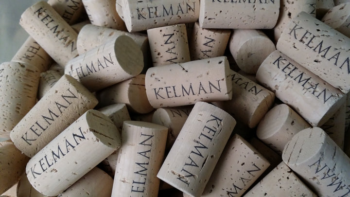 A close-up of Kelman branded corks, highlighting the attention to detail and commitment to quality at Kelman Family Vineyards.