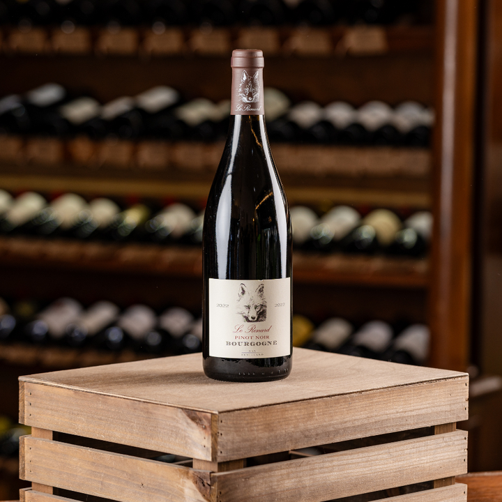 A bottle of Le Renard Bourgogne Pinot Noir on a wooden crate.