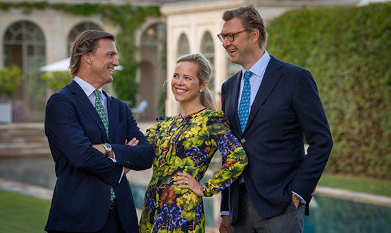 The Albada family, proprietors of Château Giscours, standing together in elegant attire at their estate, showcasing their dedication to fine winemaking.