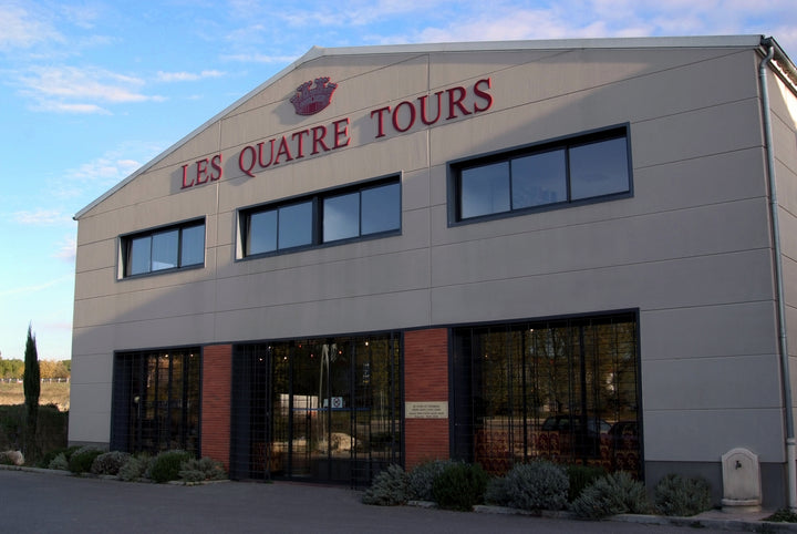 Les Quatre Tours winery building under a clear blue sky in Provence.