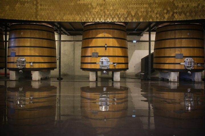 Wooden wine barrels at Château Marquis d'Alesme, showcasing traditional aging methods.