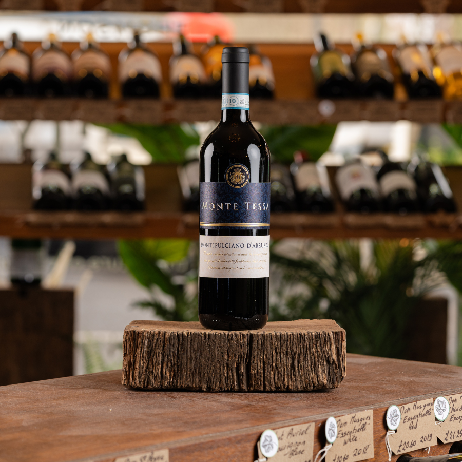 A bottle of Monte Tessa Montepulciano d'Abruzzo on a wooden display.