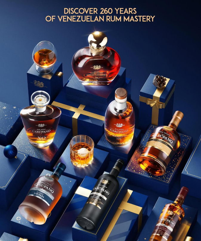 A luxurious display of Ron Carúpano rum bottles, including Reserva 12, Reserva 21, and XO, arranged on festive blue and gold gift boxes with a glass of rum.