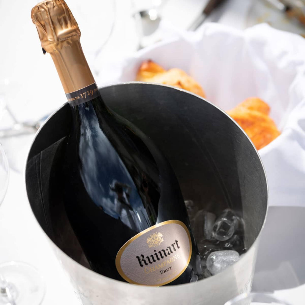 Chilled Ruinart Brut Champagne in an ice bucket, ready to be served.