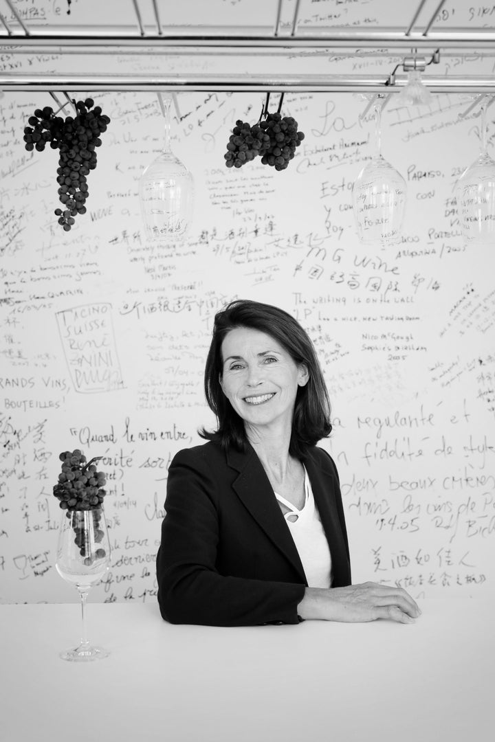 Sara Cuvelier, Managing Director, at a wine tasting desk with grape decorations at Château Léoville-Poyferré.