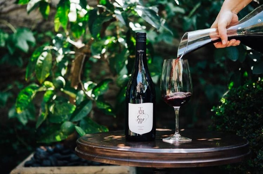 Tar & Roses Heathcote Shiraz red wine being poured into a glass from a decanter.