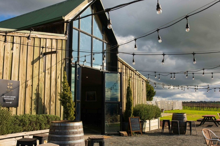 Rustic entrance to the Tokar Estate cellar door, surrounded by vineyards and decorated with string lights.