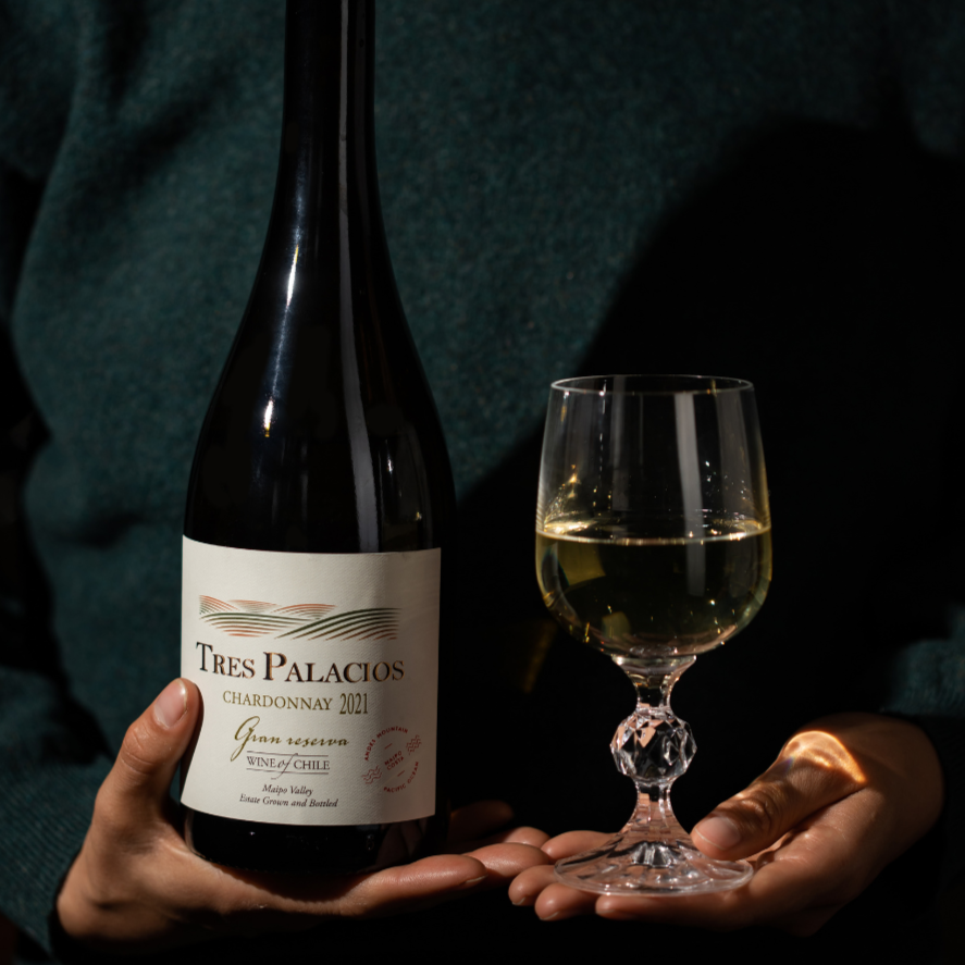 A bottle of Tres Palacios Chardonnay 2021 Gran Reserva held alongside a glass of white wine, creating a refined and elegant tasting experience.