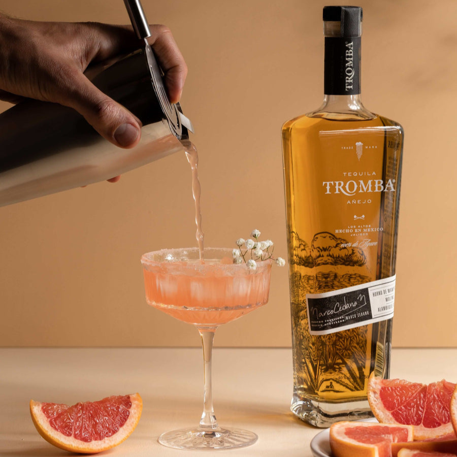 Bartender pouring a grapefruit cocktail made with Tromba Añejo Tequila, complemented by fresh grapefruit slices.