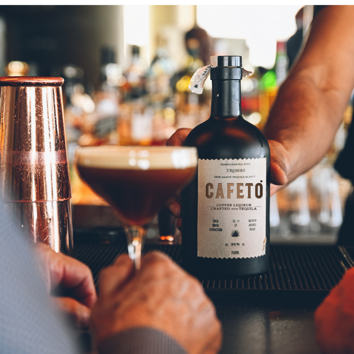 Tromba Cafeto Coffee Liqueur bottle on a bar, accompanied by an espresso martini.