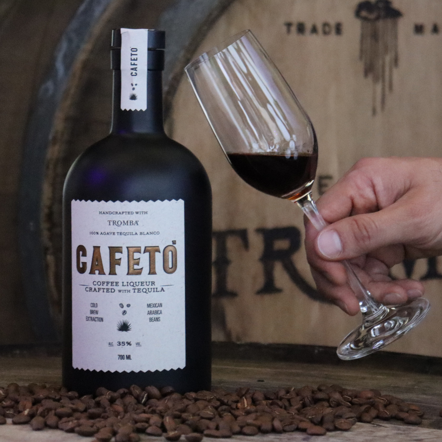 Tromba Cafeto Coffee Liqueur bottle with a glass of coffee liqueur and coffee beans.