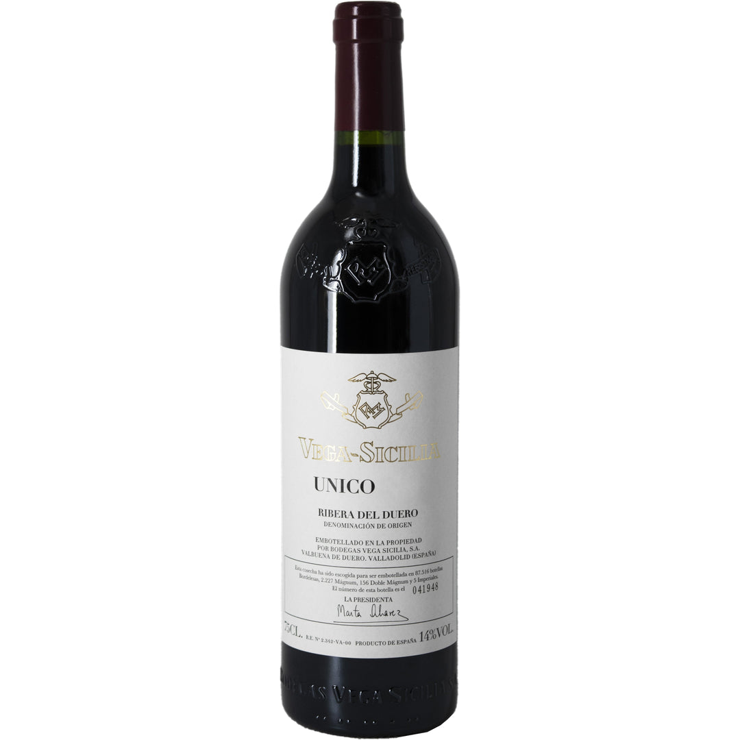 A bottle of Vega Sicilia Único, a prestigious red wine from Ribera del Duero, Spain, featuring a classic label and embossed glass.