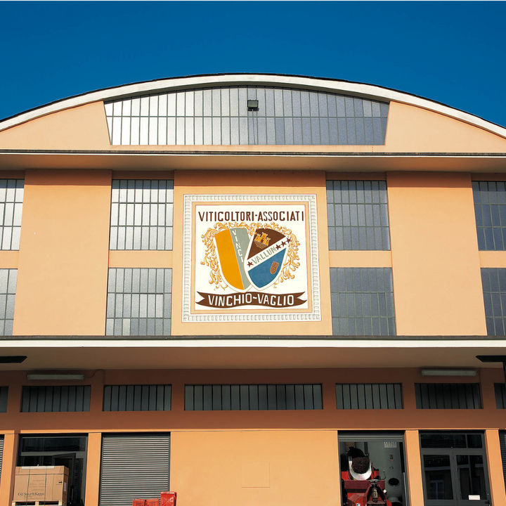 The Vinchio Vaglio winery building with its crest, located in the scenic hills of Piedmont, Italy.